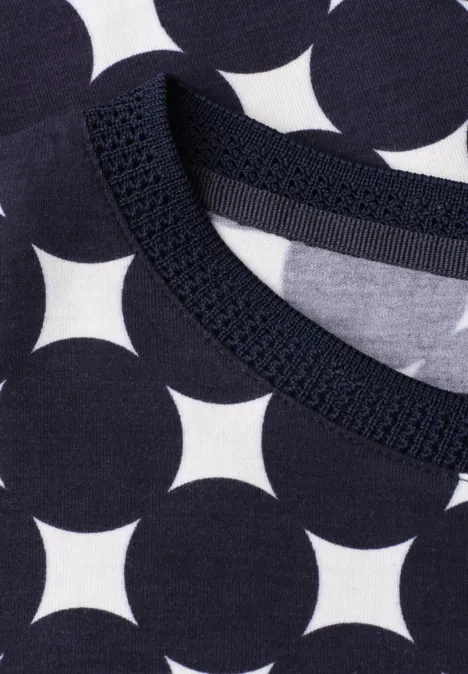 Nahaufnahme eines Shirts mit dunkelblauem Punktemuster und Rundhalsausschnitt.